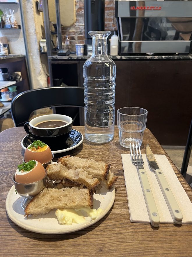 Breakfast on the table with the counter and shelving behind